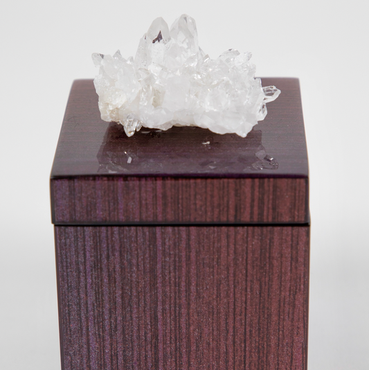 A lacquer box with a semi-precious crystal on top, clear quartz, with a dark ombre design.