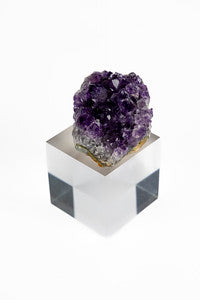 An amethyst geode set on a square acrylic base bottom