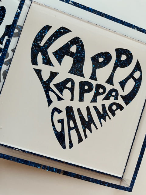 A square acrylic tray with 'KAPPA GAMMA' text in glittery black inside a blue heart-shaped border.