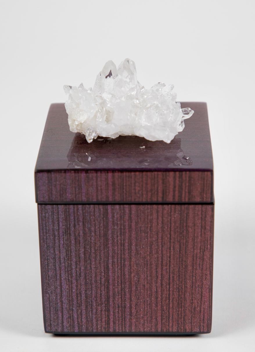 A lacquer box with a semi-precious crystal on top, clear quartz, with a dark ombre design.