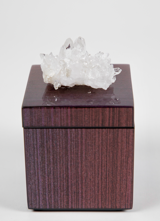 A lacquer box with a semi-precious crystal on top, clear quartz, with a dark ombre design.