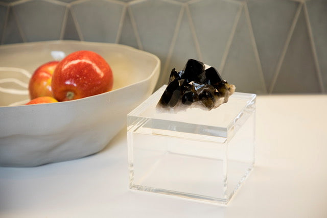 acrylic clear box with quartz crystal next to bowl